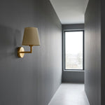Wireless fabric wall sconce installed as a functional accent on a dark grey bedroom corridor wall.